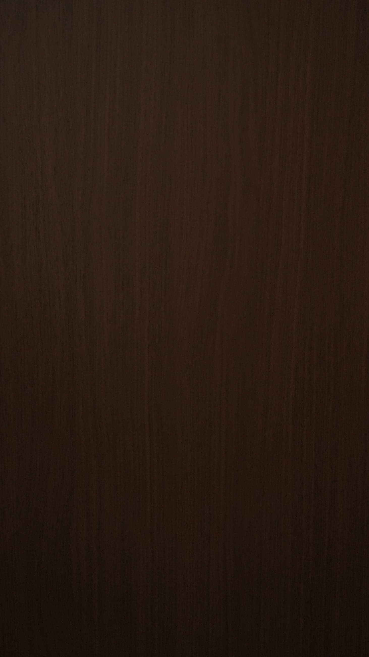 Deep chocolate-brown walnut swatch with soft, low-contrast vertical grain.